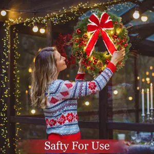 Pre-lit Christmas wreath with large red bow and pine cones for festive front door decor