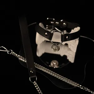 Black leather cat bell choker detail view showcasing intricate metal bell and subculture design.