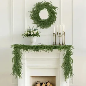 Norfolk pine garland and wreath set decorating a classic white fireplace mantel
