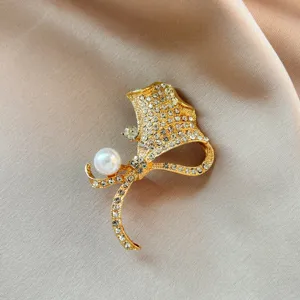 Exquisite matte gold rhinestone pearl ginkgo leaf brooch pin, elegant clothing accessory detail.