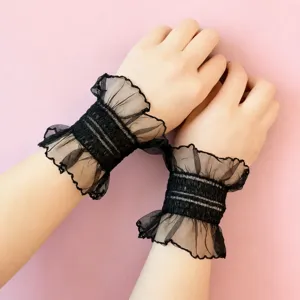 Vue détaillée de manchettes en dentelle noire à volants avec un design en mailles doubles.