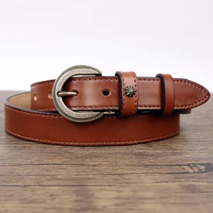 Detailed view of brown genuine leather retro belt featuring a vintage brass buckle and star rivet.
