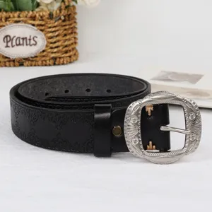 Black vintage western leather belt for women, retro carved metal buckle jeans belt detail.