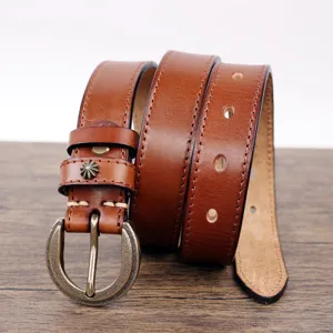Detailed view of the vintage brown leather belt with classic brass buckle and fine stitching.