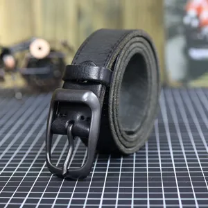 Close-up detail of black leather belt featuring textured top-grain surface and sturdy pin buckle.