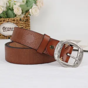 Vintage brown embossed leather belt for women with ornate carved metal buckle detail.