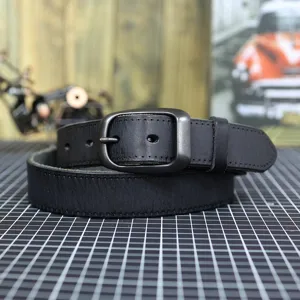 Close-up detail shot of a black genuine leather men's belt featuring a durable metal pin buckle.