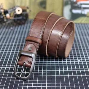 Detail view of the vintage brown genuine leather belt featuring a durable metal pin buckle.