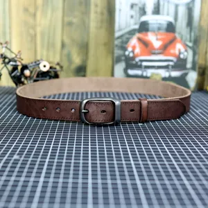Detailed view of retro casual genuine leather men belt with metal pin buckle and tool background.