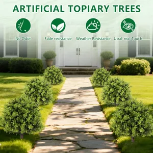 Kunstmatige buxus topiary ballen langs een zonnig tuinpad voor buitenhuisdecoratie