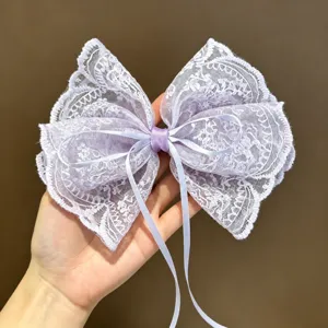 Vista detallada de una elegante horquilla de lazo de encaje morado taro con cintas delicadas.