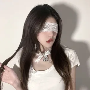 Vue détaillée du masque en dentelle blanche et collier nœud clochette pour accessoires.