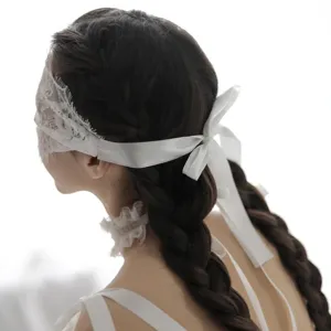 White lace blindfold with satin ribbon ties and matching choker. Elegant erotic accessory.