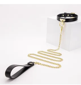 Black leather choker necklace with gold chain and handle, gothic style fashion jewelry accessory.