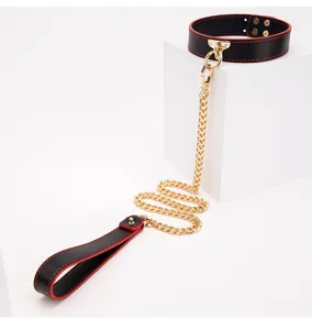 Detailed view of a black leather choker collar with red stitching and gold chain leash.