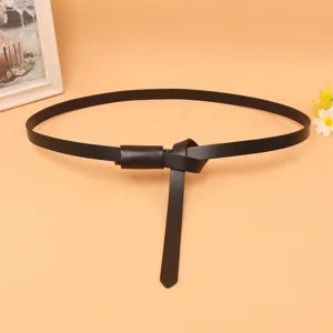 Detail of a thin black genuine leather belt tied in a stylish knot for dresses