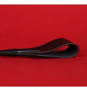 Black leather whip handle detail shot, premium craftsmanship with neat white stitching.