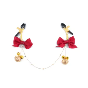 Metal nipple clamps with red bows and gold bells, sexy adult novelty toys for couples.