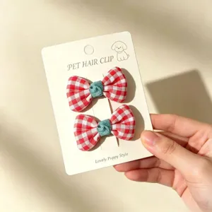 Handmade red and white checkered pet hair bow clip detail view, cute hair accessories for dogs.