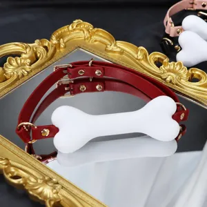 Collier de jeu de rôle en cuir rouge avec bâillon os en silicone blanc pour adultes.