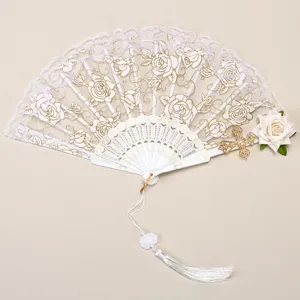 Detail view of vintage European lace folding fan with gold rose embroidery and elegant tassel.