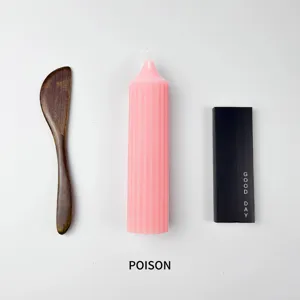 Vista detallada de la vela aromática rosa acanalada con espátula de madera y caja.