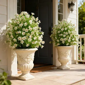 Two white artificial flower bushes in decorative urns on an outdoor porch entrance