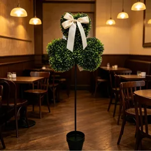 Vue détaillée d'un topiaire de trèfle artificiel avec un ruban dans un café chaleureux
