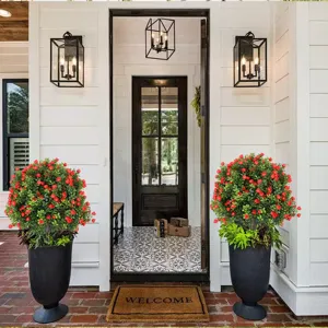 Pair of artificial topiary trees with red flowers in tall black pots for porch decoration