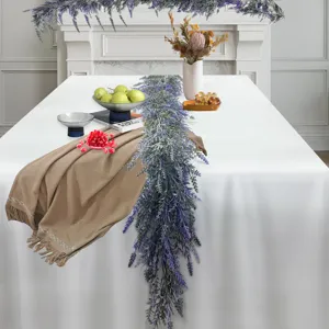 Long simulation lavender garland draped over a white dining table as centerpiece