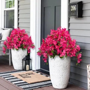 Detailopname van levendige roze kunstmatige bougainvillea bloemen in witte stenen potten