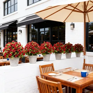 Beautiful row of six artificial red rose potted plants decorating a sunny outdoor cafe terrace.