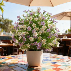Close-up of artificial purple and white Milan flowers in a minimalist white ceramic pot
