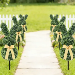 Artificial rabbit boxwood topiaries with yellow bows lining a stone path for Easter.