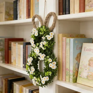 Gedetailleerde weergave van een paashaas krans met witte madeliefjes op een witte boekenkast.