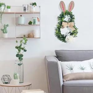 Grüner künstlicher Osterhasen-Kranz an einer minimalistischen weißen Wohnzimmerwand