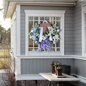 Detailed view of Easter cross wreath with lilies and plaid bow for front door décor