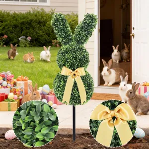 Macro view of artificial boxwood leaves and satin gold bow on Easter bunny topiary