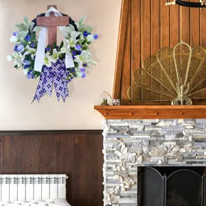 Detailed view of an Easter cross wreath with white lilies and plaid bow hanging on a wall