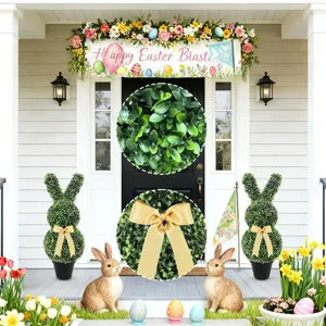 Detail view of artificial boxwood leaves and golden bow on Easter bunny topiary