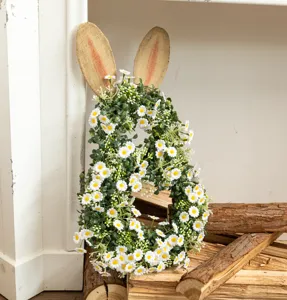 Close-up of Easter bunny wreath with white daisies and burlap ears on rustic wood