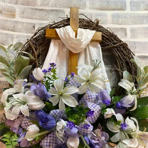 Detailed close-up of Easter wreath featuring wooden cross with white lilies and tulips