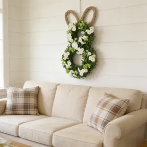 Paashaas krans met witte madeliefjes aan de muur in gezellige woonkamer decor