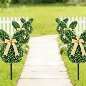 Artificial boxwood bunny topiary stakes with golden bows for Easter garden decor.