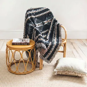Close-up of Bohemian tribal pattern woven blanket with fringe on a rattan chair