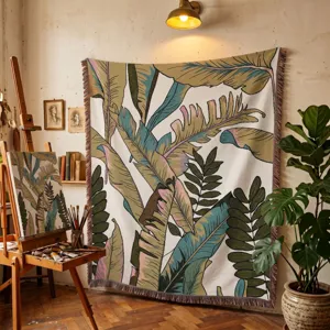 Bohemian woven tapestry throw with tropical leaf pattern hanging in a studio setting