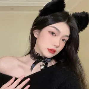 Gros plan detaille du collier choker en dentelle noire avec noeud papillon et petite cloche.