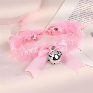 Vue détaillée du collier ras de cou en dentelle rose avec joli nœud et grande cloche argentée.