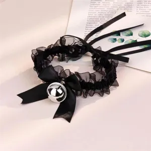 Collier choker en dentelle noire avec nœud satin et clochette argentée, style gothique.