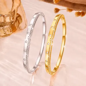 Detailed shot of delicate pave crystal slim metal bangles in silver and gold, elegant accessory.